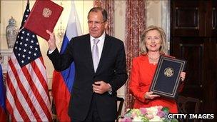 Russian Foreign Minister Sergey Lavrov and US Secretary of State Hillary Clinton hold up the agreement on adoption in Washington, DC