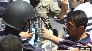 Protesters clash with riot police during a demonstration in Amman, 15 July, 2011