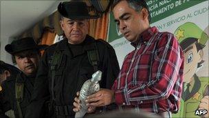 Colombia's police chief General Oscar Naranjo (C) and Defence Minister Rodrigo Rivera (R) inspect a homemade mortar shell, part of a seizure in Arauca on 17 July 2011