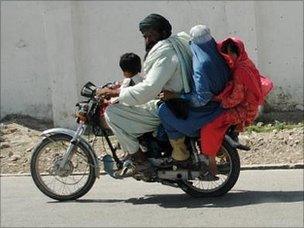 A family rides on a motorcycle in Lashkar Gah