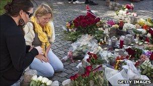 mourners pay respects with flowers in Oslo