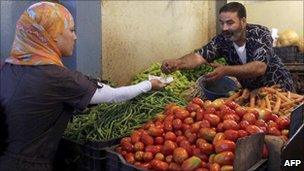 An Algerian market vendor sells vegetables to a woman in Algiers (Archive shot)