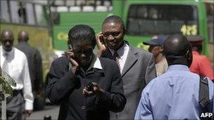 Kenyans chat on mobile phones in Nairobi (archive shot)