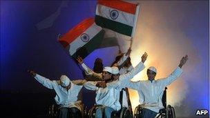 Artists in wheelchairs hold Indian flags during a performance in Bangalore on 28 May 2010