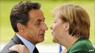 French President Nicholas Sarkozy kisses his German counterpart Angela Merkel in greeting on 20 July 2011