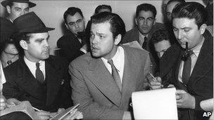 Orson Welles, centre, speaks to reporters in October 1938