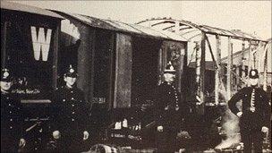 Burnt out wagons guarded by police Photo: Llanelli Library Service