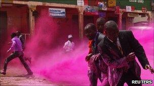Police use coloured water to disperse opposition supporters on the outskirts of Kampala