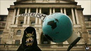 A grim reaper figure holds a globe pierced by the scythe of capitalism in front of the Bank of England during a protest on 13 October, 2008