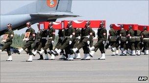 Turkish soldiers carry the coffins of soldiers who were killed in Cukurca