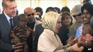 Turkish Prime Minister Recep Tayyip Erdogan (left) and his wife Emine Erdogan hold children from southern Somalia during a visit to a camp for internally displaced people in Mogadishu - 19 August 2011
