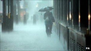 A woman in torrential rain in central London