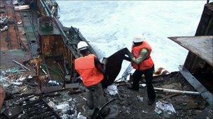 Two workers dismantle a shipwreck in Nigeria