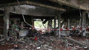 A soldier stands guard next to the damaged UN headquarters in Abuja (27 August 2011)