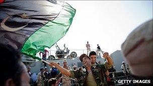 Libyan rebel soldiers from Benghazi celebrate as they arrive on an ex-Libyan Army frigate on 30 August in Tripoli, Libya