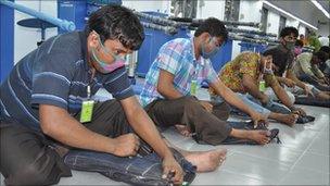 Workers at a factory in Bangladesh distressing jeans by hand