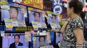 Woman shopper looks at televisions in Tokyo