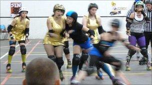 Y Bridgend Bombshells (mewn aur) yn chwarae.