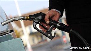Man holding nozzle of petrol pump