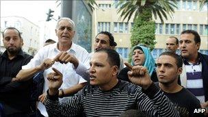 People demonstrate in front of the headquarters of the private TV station Nessma, Tunis, on 9 October 2011