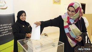 An Omani voting committee member casts her vote early in Muscat