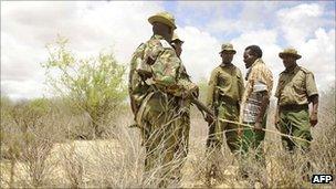 Kenyan security forces speak to a local goat herdsman on the border with Somalia on 15 October 2011