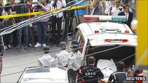 Police carry the body of Chung Ku-haeng, head of Jeil 2 Savings Bank, who jumped to his death in an apparent suicide on 23 September 2011