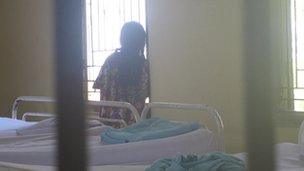 A female patient being locked behind bars at the Lawang Mental Hospital