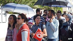 Tunisians wait to vote outside a polling station