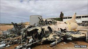 A military aircraft of Muammar Gaddafi's air force lies destroyed after a Nato strike in Sirte, 6 October 2011