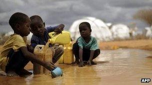 This file picture taken on 16 October 2011, shows Somali boys fetching water from a puddle that formed after rain at the IFO-2 complex in the sprawling Dadaab refugee complex in Kenya