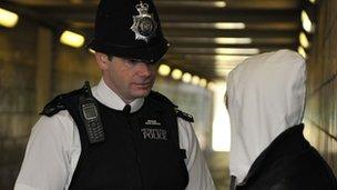 A policeman talks to a youth in London