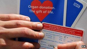 Person signing organ donation card