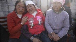 Relatives of trapped coal miners cry outside a coal mine after a gas leakage accident in Shizong county, Yunnan province November 10