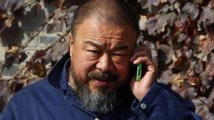 Ai Weiwei talks on his phone outside his studio on 8 November 2011