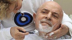 Former Brazilian President Lula da Silva poses with his wife after having his hair and beard shaved off