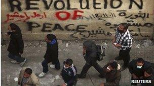 People walk past graffiti urging Tantawi to go (21 Nov 2011)