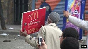 Egyptian protester holds up McDonald's sign as protection