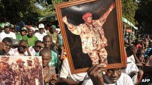 Supporters of Gambian President Yahya Jammeh hold picture of him on 22 November 2011 during a campaign meeting in Bakau