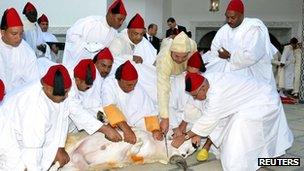 Morocco's King Mohammed VI (in gold robes) slaughters a sheep during the Muslim holiday of Eid al-Adha in Rabat 7 November, 2011.