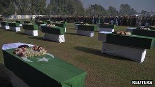 Pakistan's national flags cover the caskets of soldiers killed in a cross-border attack along the Pakistan-Afghan border during their funeral prayers