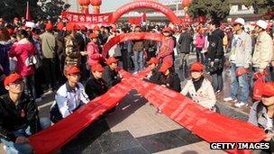 AIDS activists form a red ribbon, marking the World's AIDS day in Zhengzhou, central China's Henan province, 1 December 2010