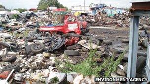 Large piles of scrap metal and tyres at a waste dump