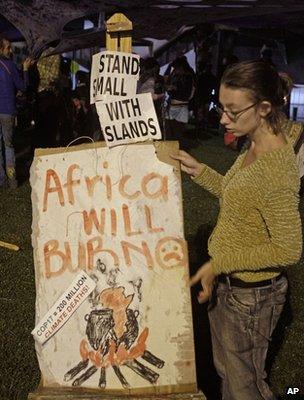 Protester holding a night-time vigil outside the conference hall, Durban (Image: AP)