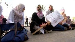 Women with their mouths' taped attend a protest outside the interim prime minister's office in Tripoli