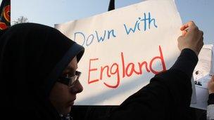 A protester holds a poster displaying the message 'Down with England' in Tehran
