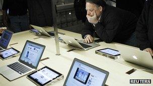 Shopper looks at Apple's laptops
