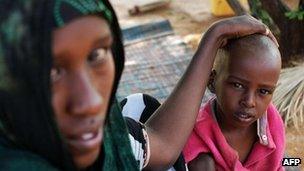 Refugee Abshiro Isakbul sits by her sick son at the Transit Centre in Dolo Ado, Ethiopia, on December 15, 2011.