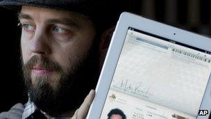 Martin Reisch holds up his iPad displaying his scanned passport