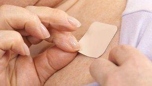 Woman putting on nicotine patch